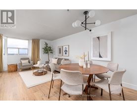 A dining room with a round table and chairs.