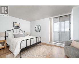 A bedroom with a bed, a chair, and a window.
