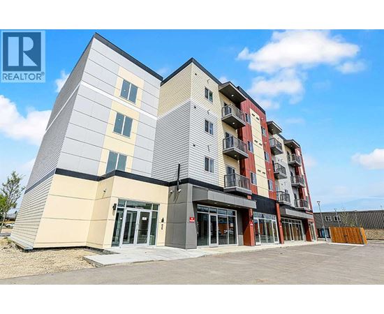 A modern apartment building with a clear blue sky in the background.