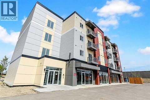 A modern apartment building with a clear blue sky in the background.
