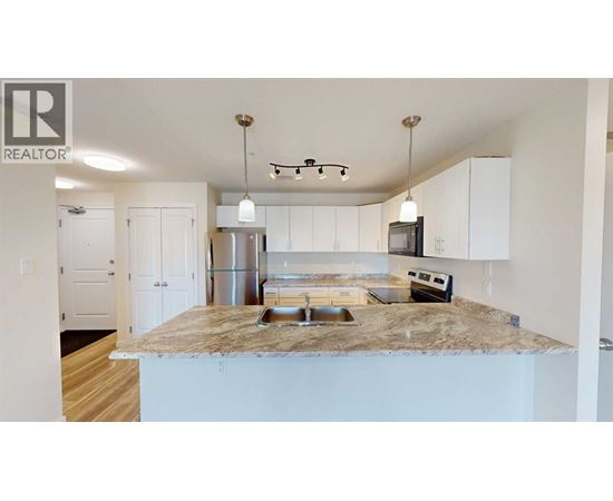 A kitchen with a granite countertop and white cabinets.