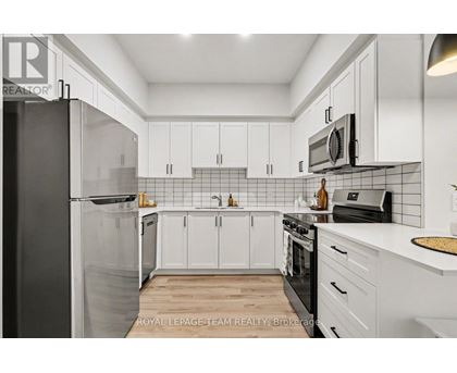 A kitchen with white cabinets and black appliances.