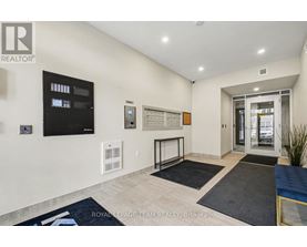 A well-lit, spacious living room with a flat-screen TV, a whiteboard, and a glass door leading to another room.
