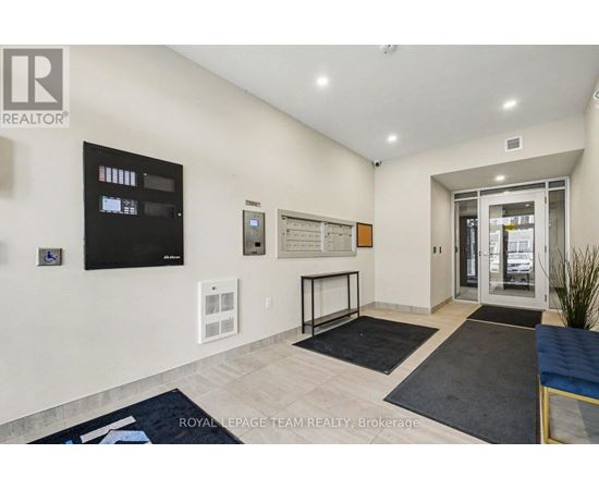 A well-lit, spacious living room with a flat-screen TV, a whiteboard, and a glass door leading to another room.