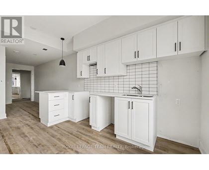 A kitchen with white cabinets and a sink.