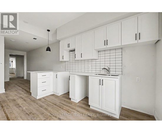 A kitchen with white cabinets and a sink.