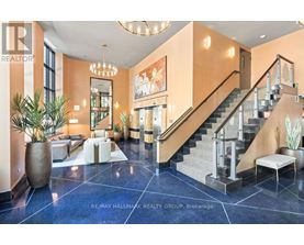 A spacious foyer with a staircase and a large mirror.