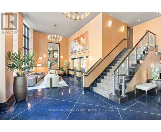 A spacious foyer with a staircase and a large mirror.