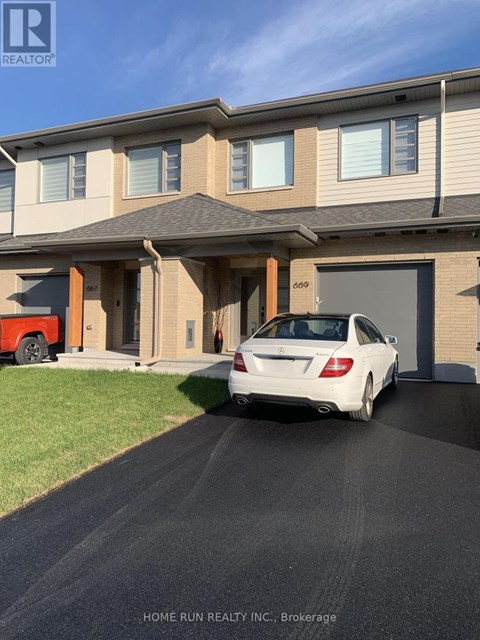 A white car is parked in front of a two-story house.
