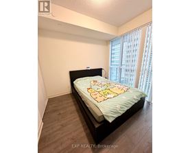 A bedroom with a bed and a window with blinds.