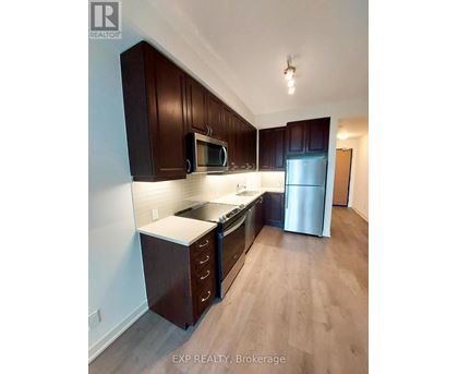 A kitchen with dark wood cabinets and stainless steel appliances.
