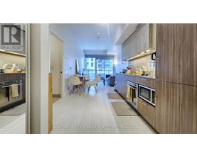 A modern kitchen with wooden cabinets and a dining area with chairs.