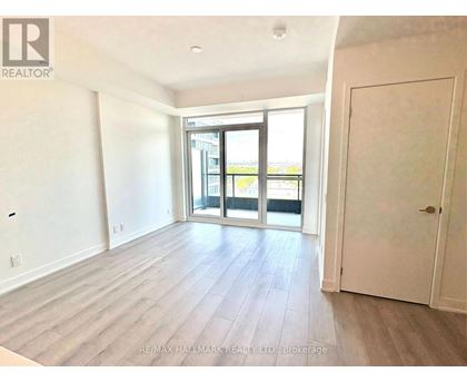 A spacious room with a sliding glass door leading to a balcony.
