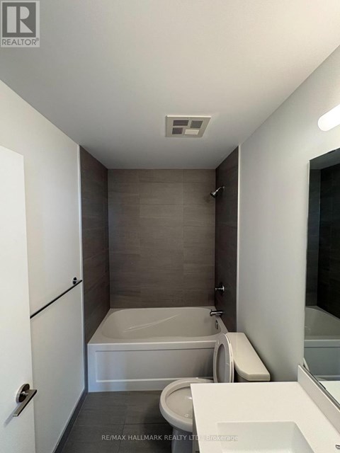 A bathroom with a toilet, sink, and bathtub.