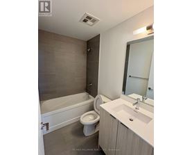 A bathroom with a white tub, toilet, and sink.