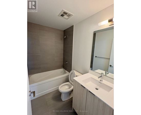 A bathroom with a white tub, toilet, and sink.