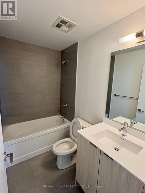 A bathroom with a white tub, toilet, and sink.