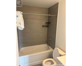 A white toilet with a white towel hanging on a towel rack.