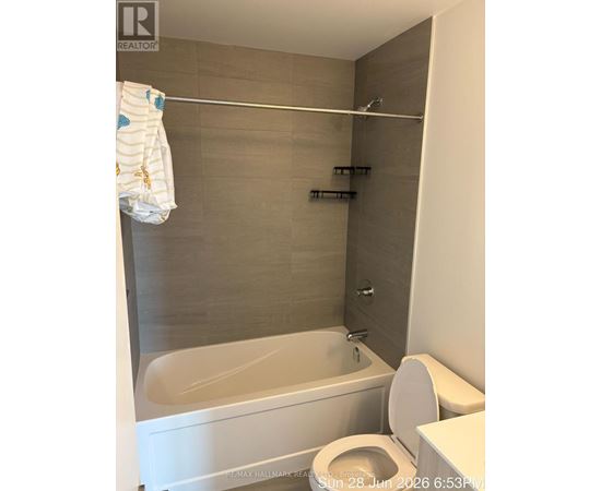 A white toilet with a white towel hanging on a towel rack.