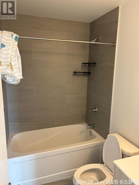 A white toilet with a white towel hanging on a towel rack.