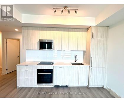 A modern kitchen with white cabinets and appliances.