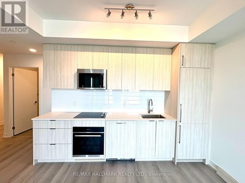 A modern kitchen with white cabinets and appliances.