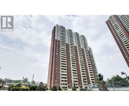 A tall residential building with a fence in front of it.