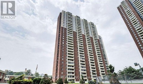 A tall residential building with a fence in front of it.
