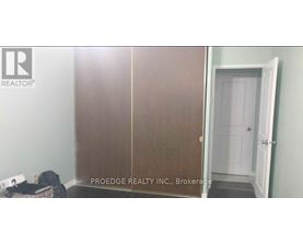 A room with a white door and a sign that says Proedge Realty Inc. Brokerage.