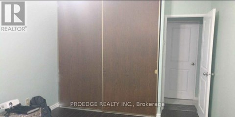 A room with a white door and a sign that says Proedge Realty Inc. Brokerage.