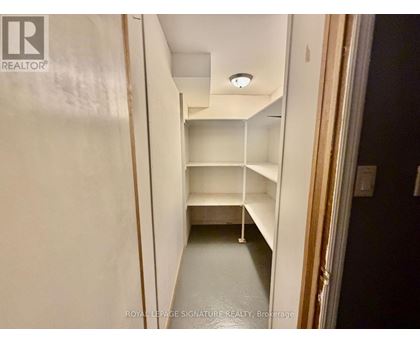 A white hallway with shelves and a light on the ceiling.