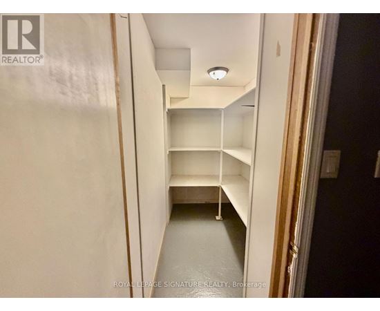 A white hallway with shelves and a light on the ceiling.
