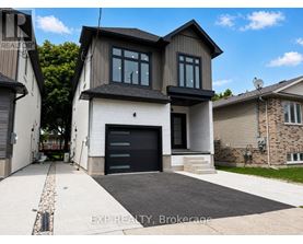 A modern house with a black garage door is for sale.