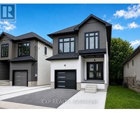 A modern house with a black garage door is for sale.