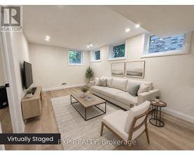 A living room with a white couch, a coffee table, and a flat screen TV.