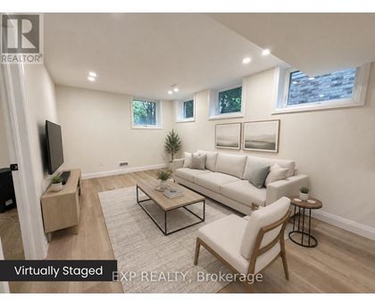 A living room with a white couch, a coffee table, and a flat screen TV.