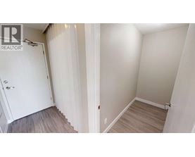 A white door is on the left and a wooden floor is on the right.