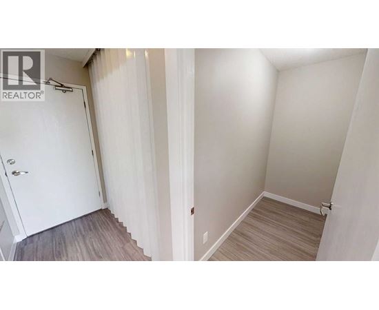 A white door is on the left and a wooden floor is on the right.
