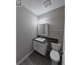 A small bathroom with a toilet, sink, and mirror.