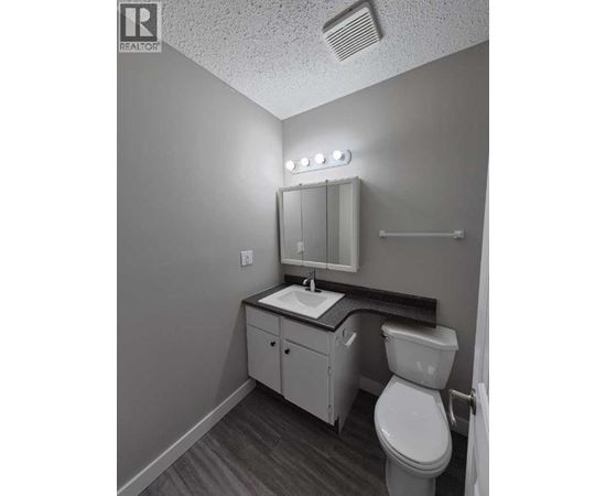 A small bathroom with a toilet, sink, and mirror.