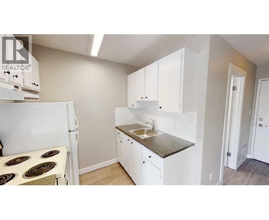 A small kitchen with white cabinets and a sink.