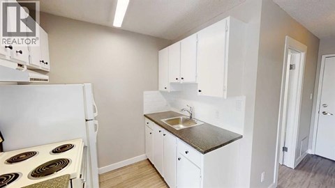 A small kitchen with white cabinets and a sink.