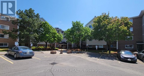 A parking lot with cars and a sign that says "Right at Home Realty, Brokerage".