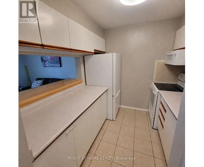 A kitchen with white cabinets and appliances.