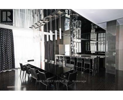 A modern dining room with a glass table and chairs.
