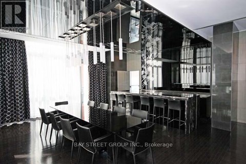 A modern dining room with a glass table and chairs.