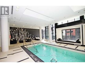 A large indoor swimming pool with a black and white tiled floor.