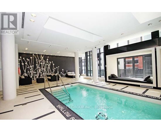 A large indoor swimming pool with a black and white tiled floor.