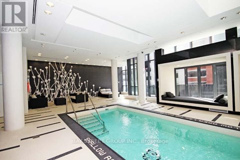 A large indoor swimming pool with a black and white tiled floor.