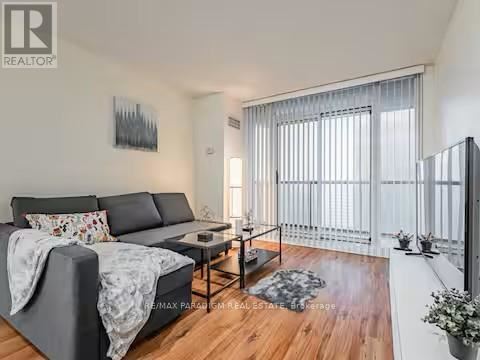 A living room with a grey sofa and a wooden floor.